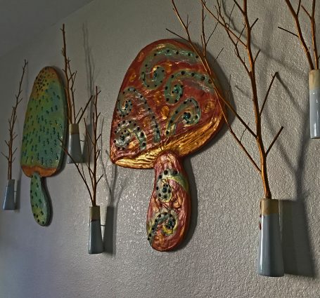 close-up of mushroom in green, gold, and orange with red, white and blue mountain vessels