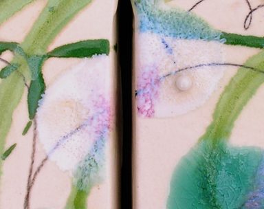 Detailed view of ceramic wall art with bold green and turquoise glazes melting into each other with black ceramic pencil cursive lines. 
